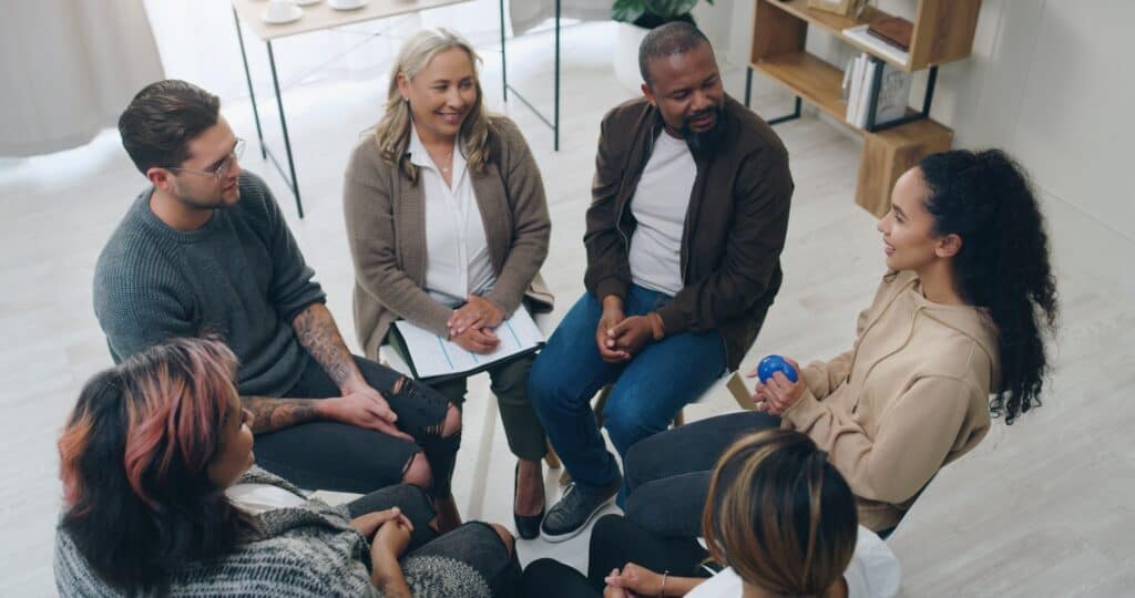 Team building, therapy group and people in circle for mental health support, communication and coun
